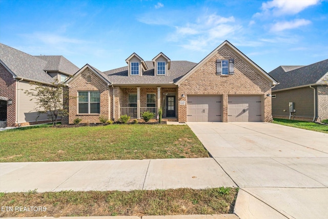 view of front of home with a garage, a porch, and a front lawn