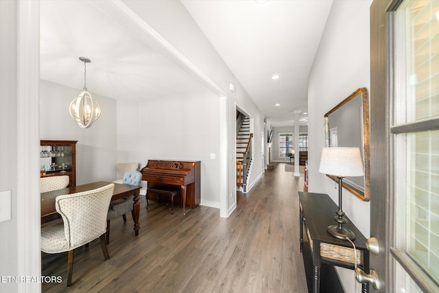 hallway featuring dark wood-type flooring and an inviting chandelier