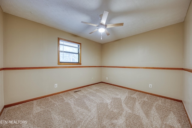 carpeted spare room with a textured ceiling and ceiling fan