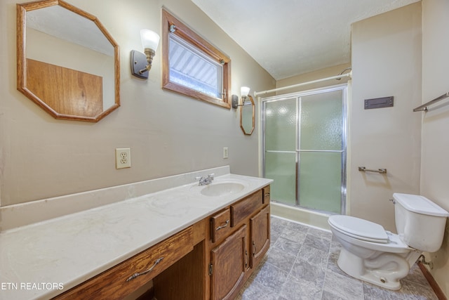 bathroom with a shower with shower door, vanity, and toilet