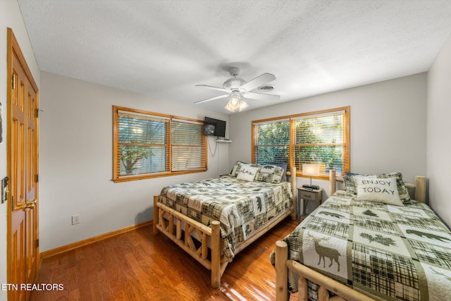 bedroom featuring a textured ceiling, hardwood / wood-style flooring, and ceiling fan