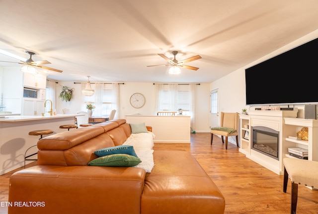 living room with ceiling fan and light hardwood / wood-style floors