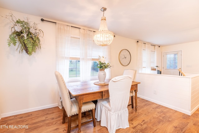 dining space featuring light hardwood / wood-style flooring and a chandelier