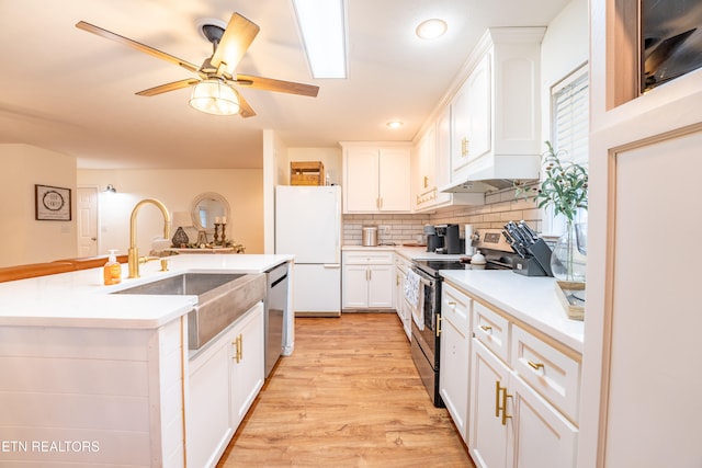 kitchen with white cabinetry, appliances with stainless steel finishes, decorative backsplash, sink, and light hardwood / wood-style flooring