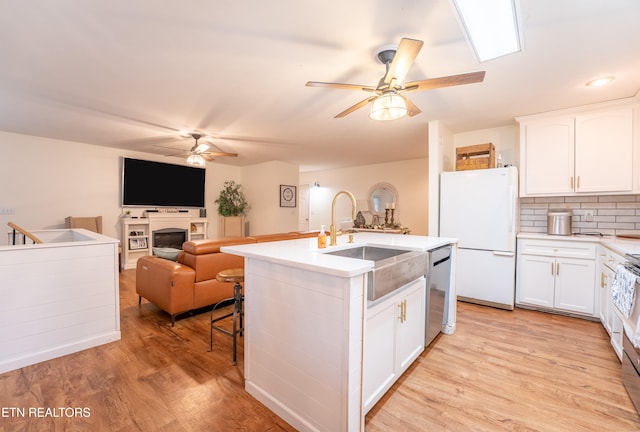 kitchen with light hardwood / wood-style flooring, white cabinets, sink, and stainless steel appliances