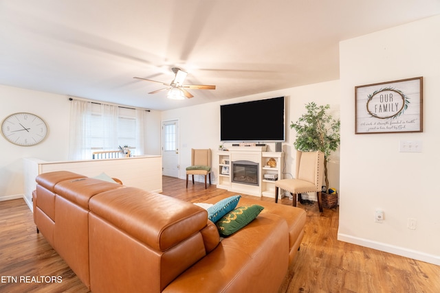 living room with light hardwood / wood-style flooring and ceiling fan