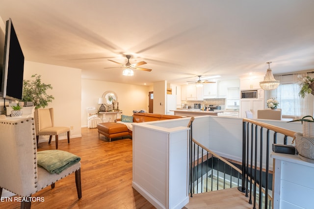 living room with light hardwood / wood-style floors and a notable chandelier