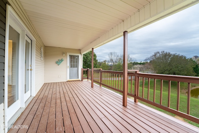 wooden terrace featuring a yard