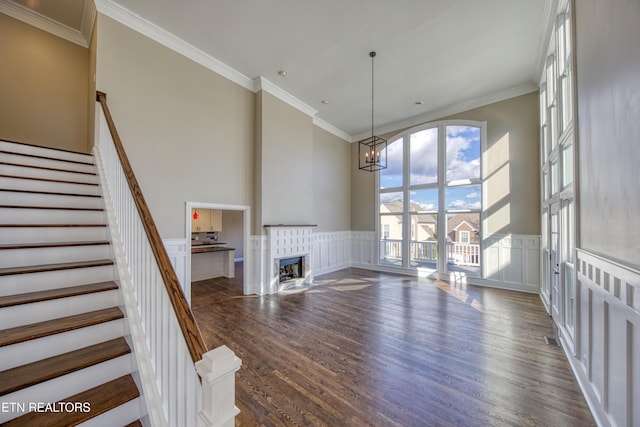 2011 Breakers Pt, Knoxville, TN 37922 - unfurnished living room featuring a chandelier, a towering ceiling, dark wood-style flooring, a decorative wall, and stairway