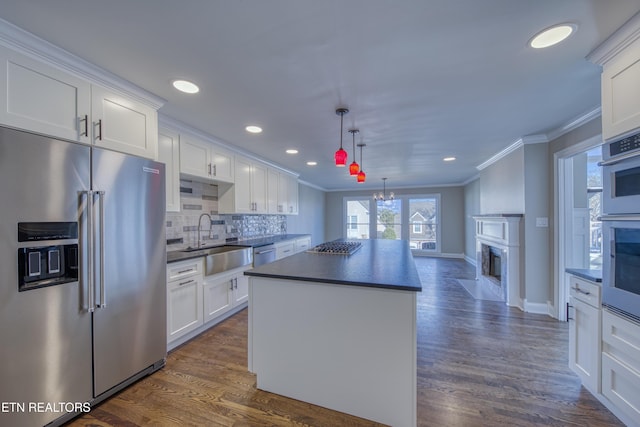 2011 Breakers Pt, Knoxville, TN 37922 - kitchen with stainless steel appliances, a sink, ornamental molding, dark countertops, and a center island