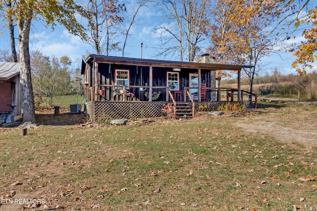 view of front facade featuring cooling unit, a front lawn, and covered porch