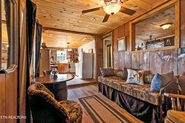 living room featuring ceiling fan, wood walls, hardwood / wood-style floors, and wooden ceiling