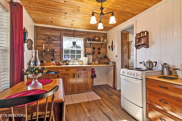 kitchen featuring pendant lighting, wood walls, hardwood / wood-style floors, and electric range