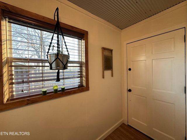 hall featuring dark wood-type flooring, a wealth of natural light, and wood ceiling