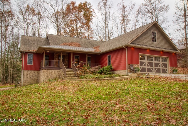 view of front of home with a porch, a garage, and a front yard