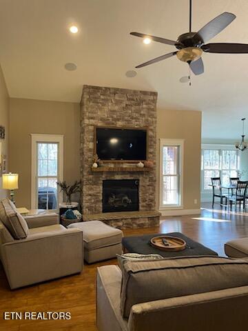 living room featuring a stone fireplace, ceiling fan, and hardwood / wood-style flooring