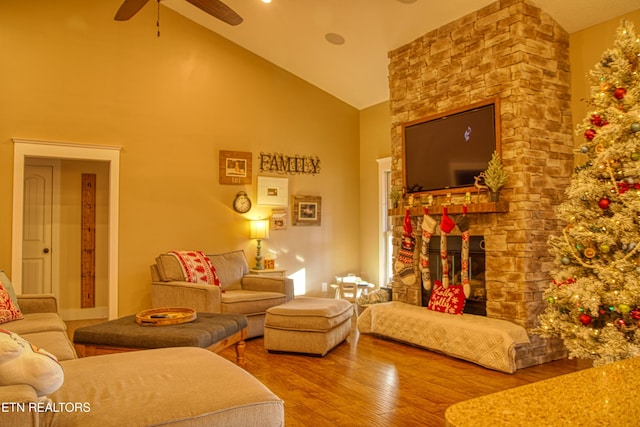 living room featuring a fireplace, hardwood / wood-style floors, high vaulted ceiling, and ceiling fan