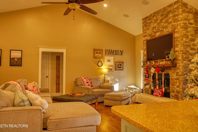 living room featuring a stone fireplace, ceiling fan, high vaulted ceiling, and wood-type flooring