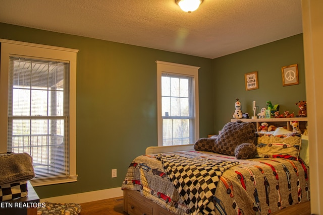 bedroom featuring hardwood / wood-style floors and a textured ceiling