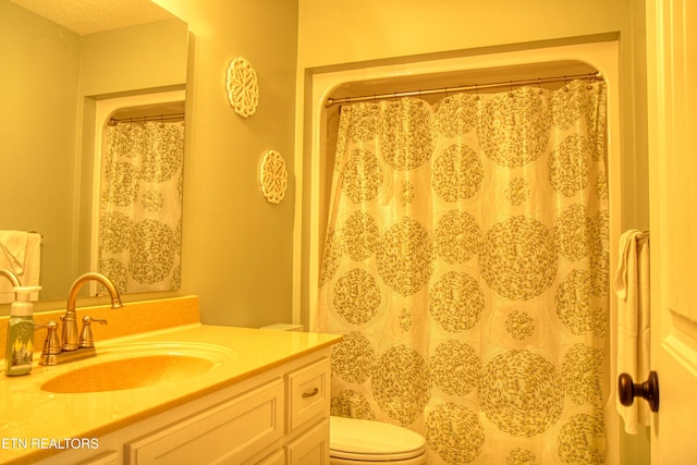 bathroom featuring walk in shower, vanity, a textured ceiling, and toilet