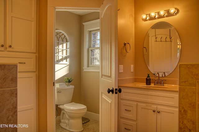 bathroom featuring tile patterned floors, vanity, and toilet