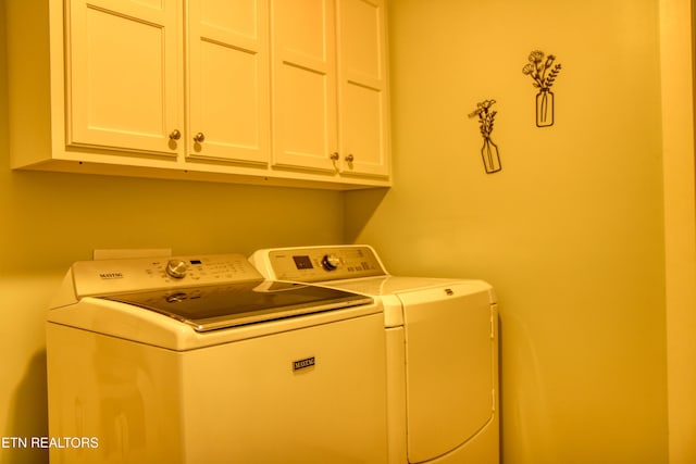 laundry area featuring washer and dryer and cabinets