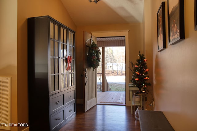 doorway featuring dark hardwood / wood-style floors and lofted ceiling