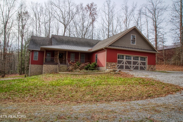 view of front of home featuring a front lawn, a porch, and a garage