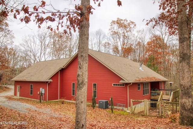 view of side of property with cooling unit and a wooden deck