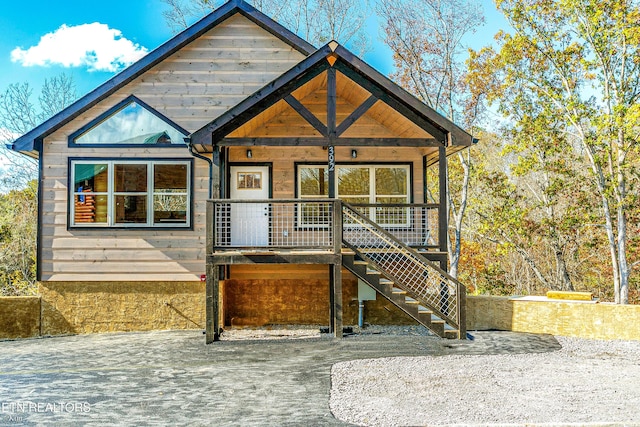 view of front of property featuring covered porch and stairway