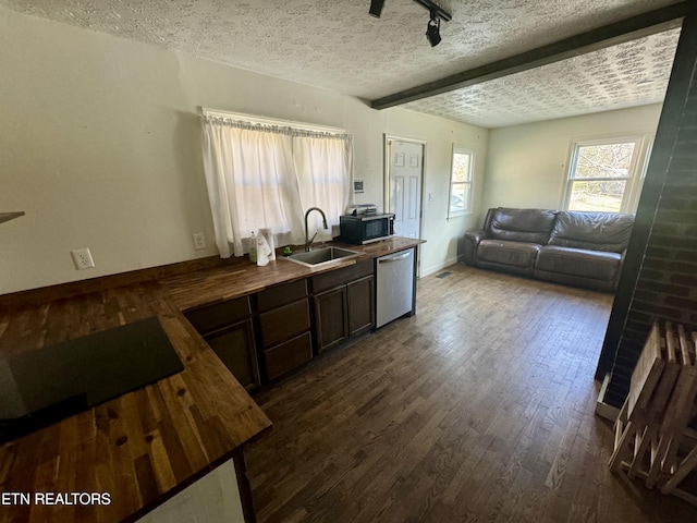 kitchen featuring dishwasher, sink, dark hardwood / wood-style flooring, stovetop, and a textured ceiling