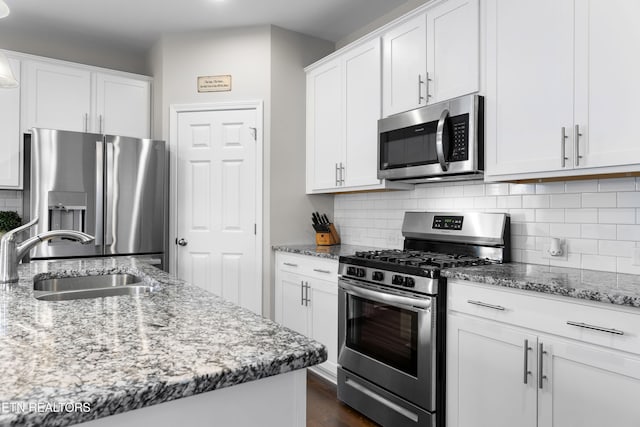 kitchen with decorative backsplash, sink, white cabinets, and stainless steel appliances