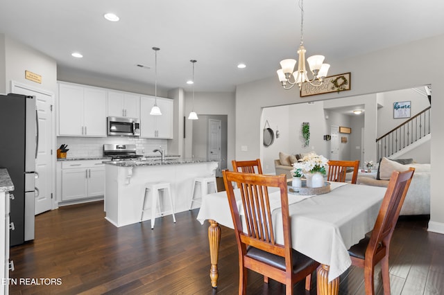 dining room featuring a notable chandelier, dark hardwood / wood-style floors, and sink