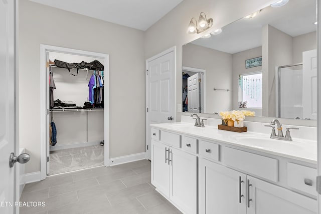 bathroom with tile patterned flooring, vanity, and walk in shower