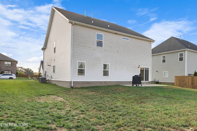 rear view of house with a lawn, central AC, and a patio