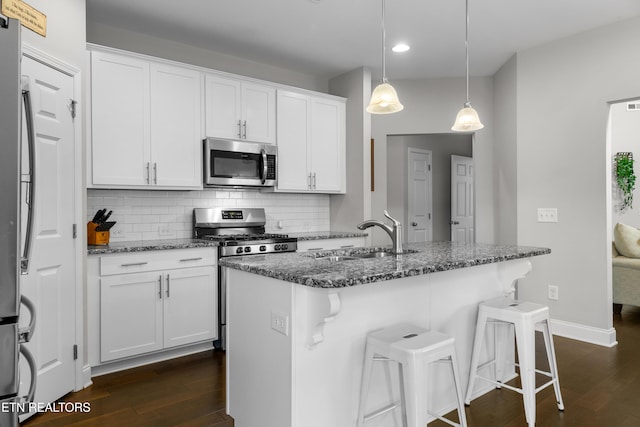 kitchen featuring white cabinetry, sink, decorative light fixtures, and appliances with stainless steel finishes