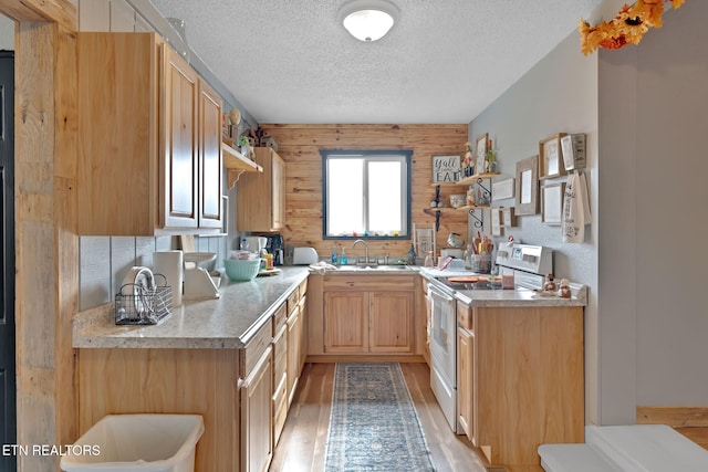 kitchen with sink, light brown cabinetry, white range with electric cooktop, light hardwood / wood-style flooring, and wooden walls