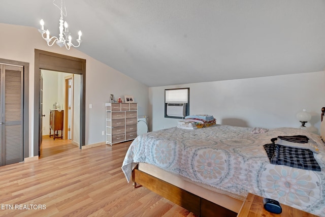 bedroom featuring lofted ceiling, cooling unit, an inviting chandelier, a closet, and light hardwood / wood-style flooring