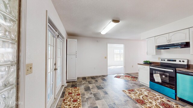 kitchen with white cabinets, a textured ceiling, and appliances with stainless steel finishes