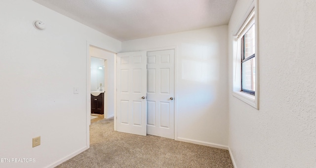 unfurnished bedroom with light carpet and sink