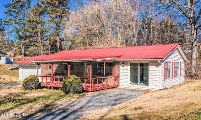 ranch-style home with a garage, covered porch, and a front yard