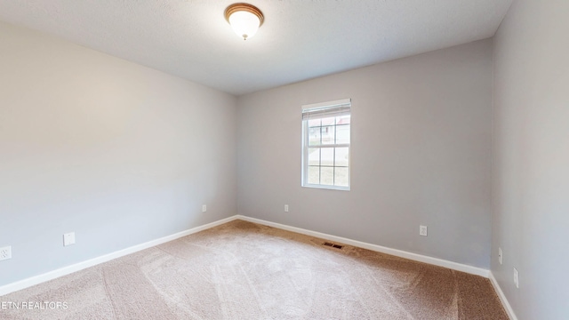 spare room featuring a textured ceiling and carpet floors