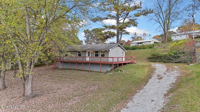 rear view of property featuring a wooden deck and a yard