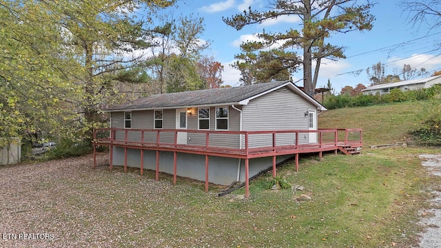 rear view of house featuring a deck and a lawn