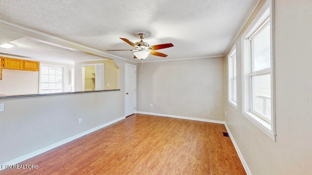 spare room featuring ceiling fan, a textured ceiling, light hardwood / wood-style flooring, and ornamental molding