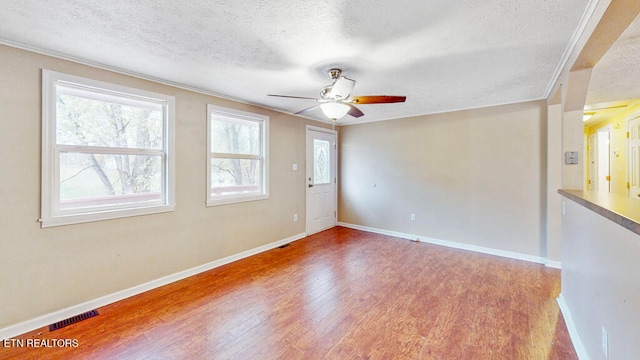 spare room featuring hardwood / wood-style floors, ceiling fan, and a textured ceiling