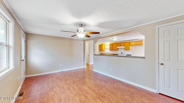 unfurnished living room with wood-type flooring, ceiling fan, and crown molding