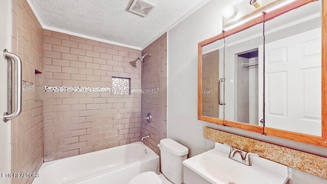 full bathroom featuring toilet, a textured ceiling, sink, tiled shower / bath combo, and ornamental molding