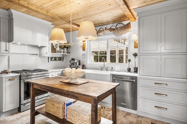 kitchen with sink, appliances with stainless steel finishes, beam ceiling, custom range hood, and decorative light fixtures