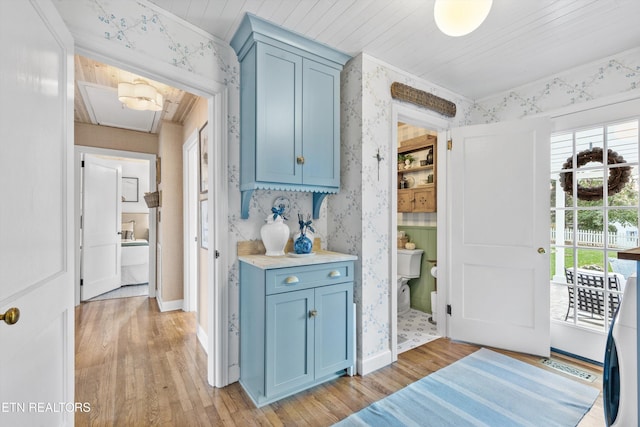 kitchen with blue cabinetry and light hardwood / wood-style floors